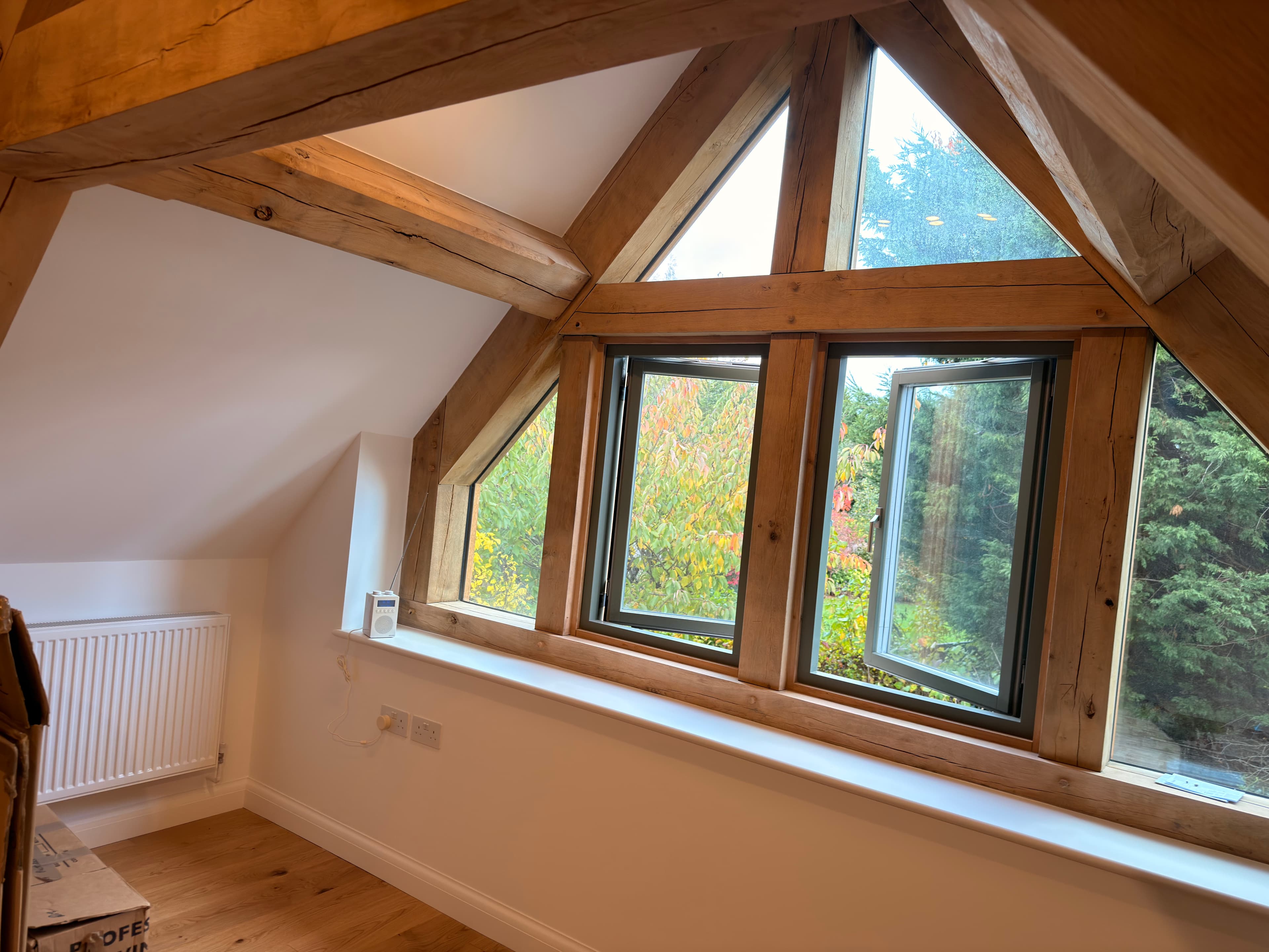 Green oak frame and gable glazing in a bedroom
