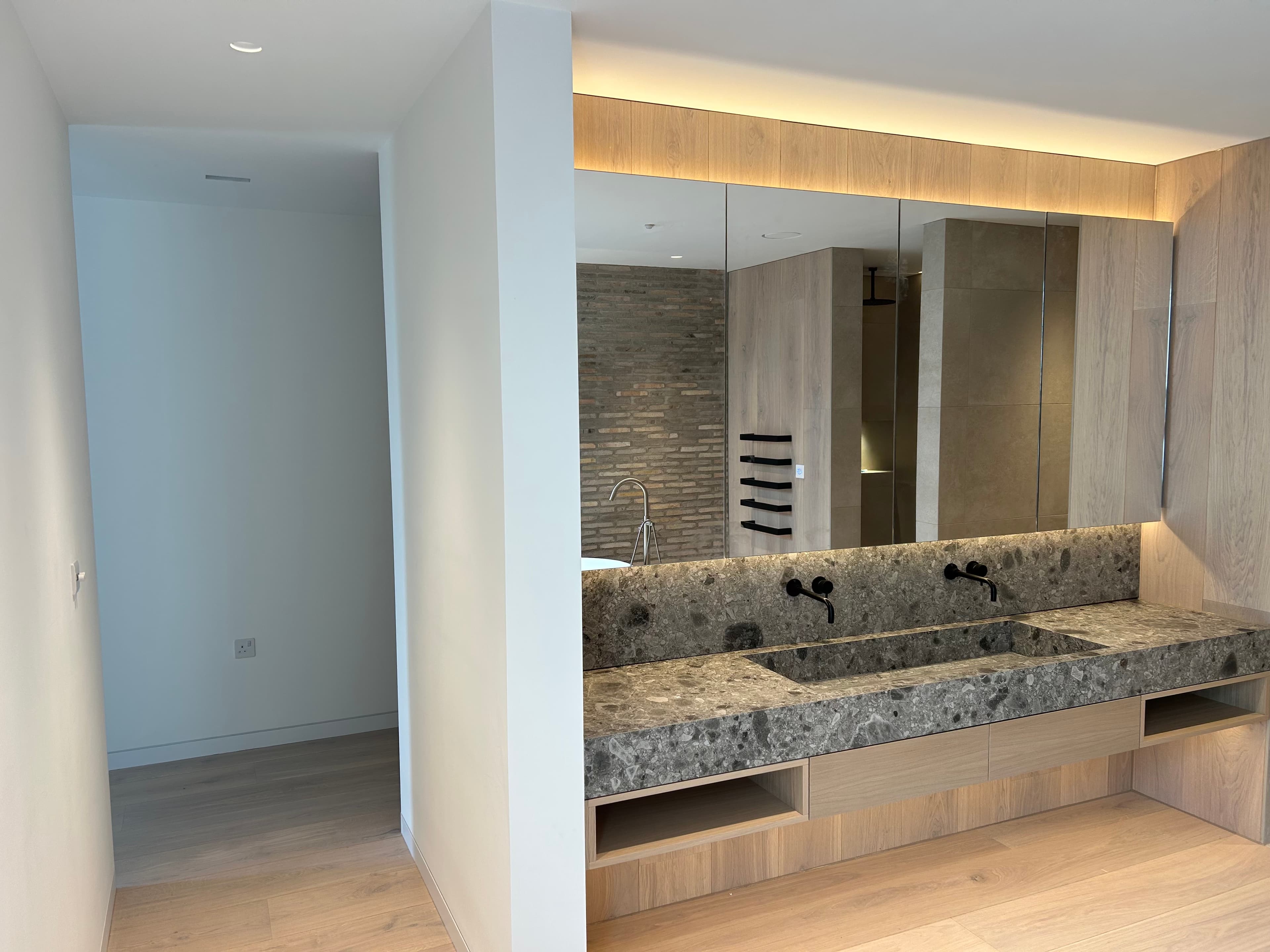 Oak-lined bathing room with stone vanity